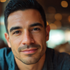 Portrait of a Latino man in his 30s with short dark hair and a friendly expression, blurred background.